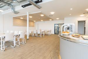 die Mensa mit den Tischen und Stühlen